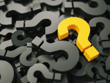 Image of yellow question mark lying atop a pile of black colored question marks