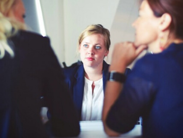 young professional in meeting with two other women