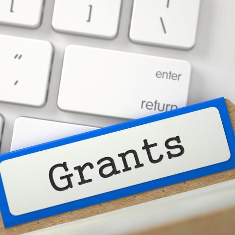 Keyboard with file folder tab on top labeled "Grants"