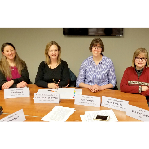 Four new board members seated at conference table