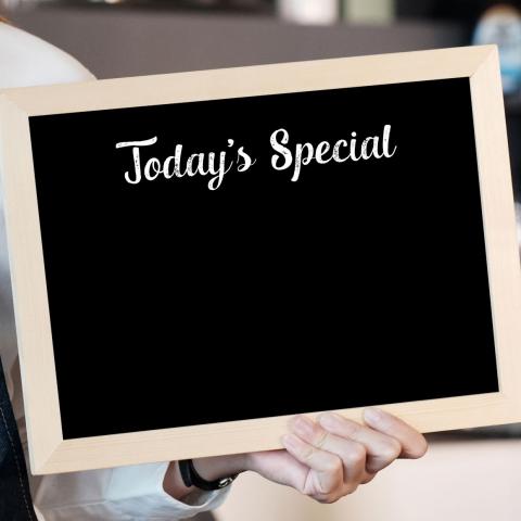 person holding chalk board sign that says "Today's Special"