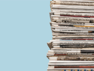 image of stacked neatly stacked newspapers