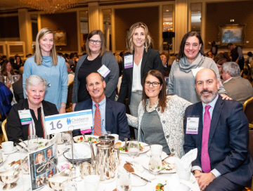 Children's Wisconsin staff posing for photo around their sponsored luncheon table at National Philanthropy Day