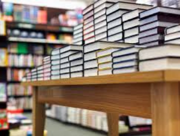 photo of hundreds of books stacked on a table in a book store
