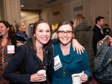 AFP Members, Ellen Wilkenson and Megan Warlin posing for photo with arms around each other and holding coffee cups