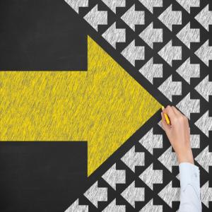 chalk drawn image of big yellow arrow pointing right into a field of small white arrows pointing left