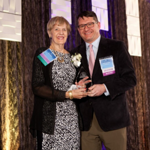 Photo of Doris Heiser, honoree being presented with crystal award from Ryan Amundson, Award Sponsor