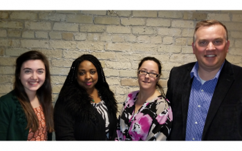 Four 2018 new board members posing in front of a brick wall