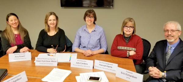 Five new board members seated at conference table