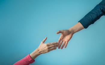 two female hands reaching for each other depicting a "helping hand"