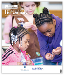 Cover of Milwaukee Business Journal's 2019 Partners in Philanthropy magazine with image of two young black girls working on a crafts project together