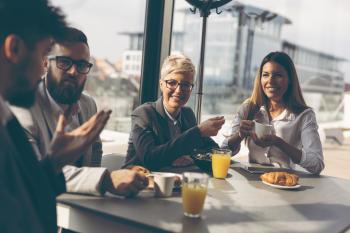 four professionals having a breakfast meeting