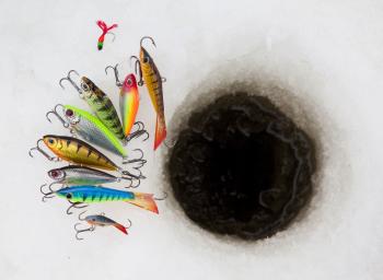 image of ice fishing hole with lures laid out next to it