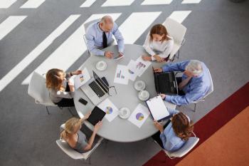 A sales team checking some graphs on a round table stock photo