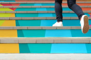 person stepping up colorful stairs