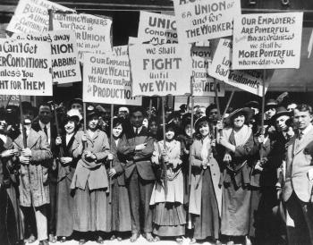 image from Progressive Era of large group of women and men holding signs with worker's rights slogans