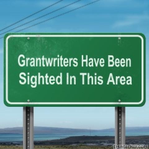 Highway sign with words "Grantwriters Have Been Sighted In This Area"