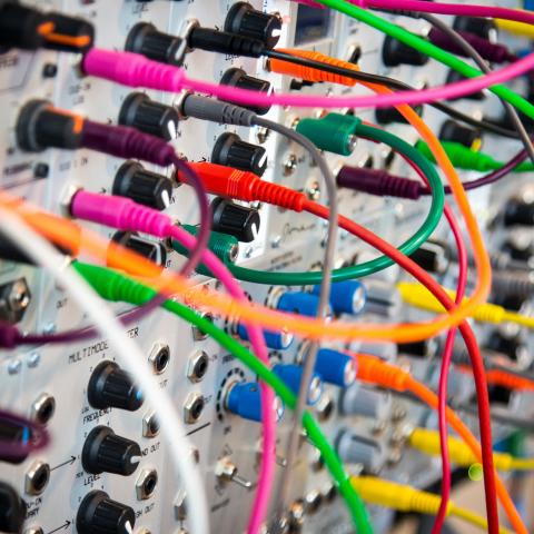 colorful wires plugged into massive receiver with dials and switches