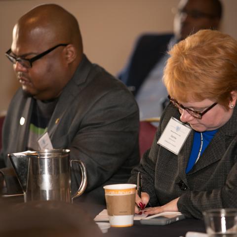 black man and red headed woman working at table during a workshop