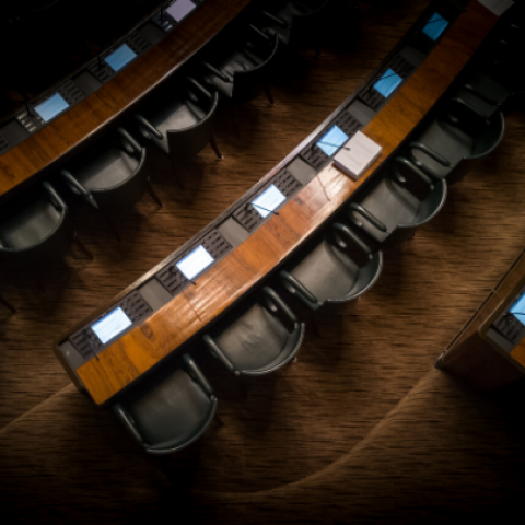 overlooking arced rows of leather chairs side by side along congress style desks