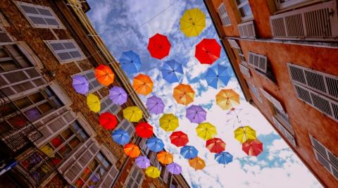 multicolor umbrellas against two buildings in the sky