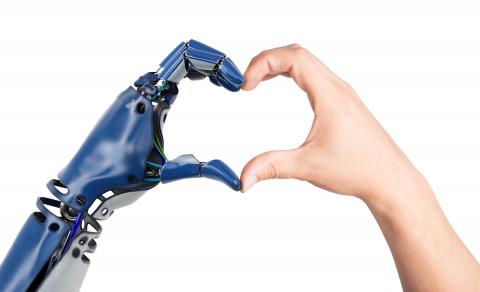Robot and human hands forming a heart