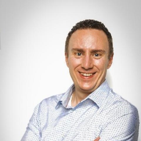 A white man holding crossing his arms