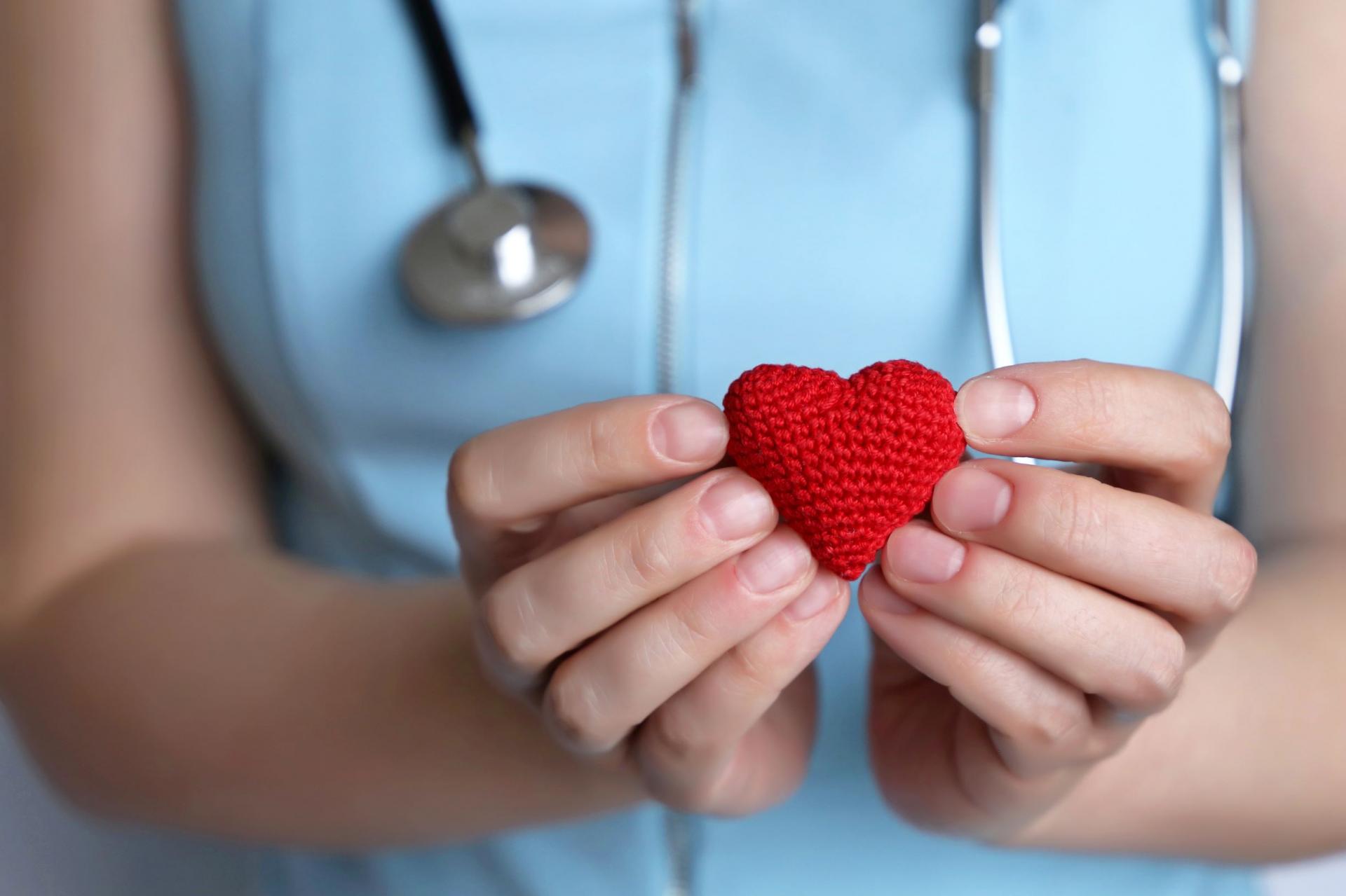 medical worker holding knit heart