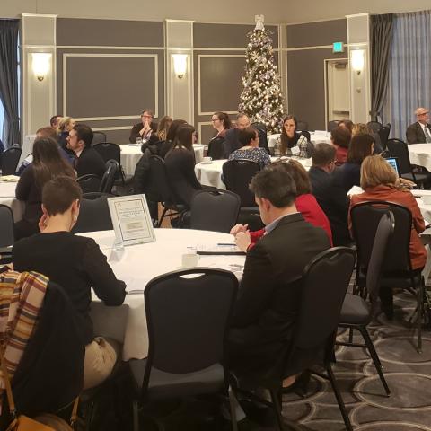 Attendees seated at tables per education topic at ICC