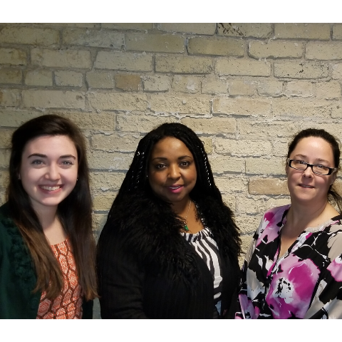 Four new 2018 board members posing in front of a brick wall