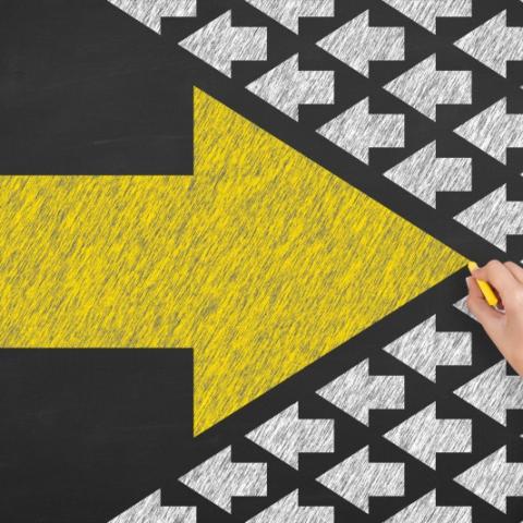 image being drawn in chalk - big yellow arrow pointing into field of small white arrows pointing the opposite direction. Depicting Impact