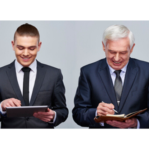 Millennial and seasoned professional both in suits standing together working on their tablet and portfolio