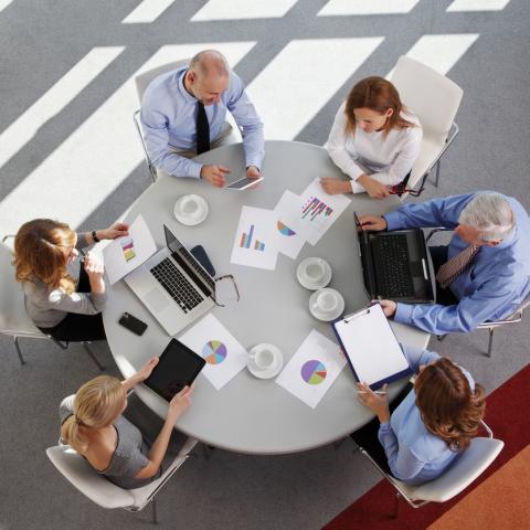 A sales team checking some graphs on a round table stock photo