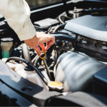photo of person checking oil in car engine