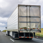 image of back of a shiny semi-truck on the highway