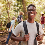 black male millennial hiking with other young people