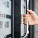 image of hand opening a door to a store