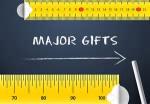 Major Gifts written on a chalk board with measuring tape trimming the top and bottom
