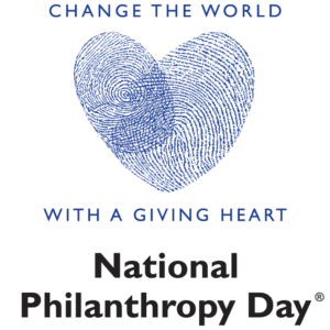 A blue heart made of overlapping fingerprints, with the text "Change the World With a Giving Heart" above and below, and "National Philanthropy Day" in bold black letters underneath.